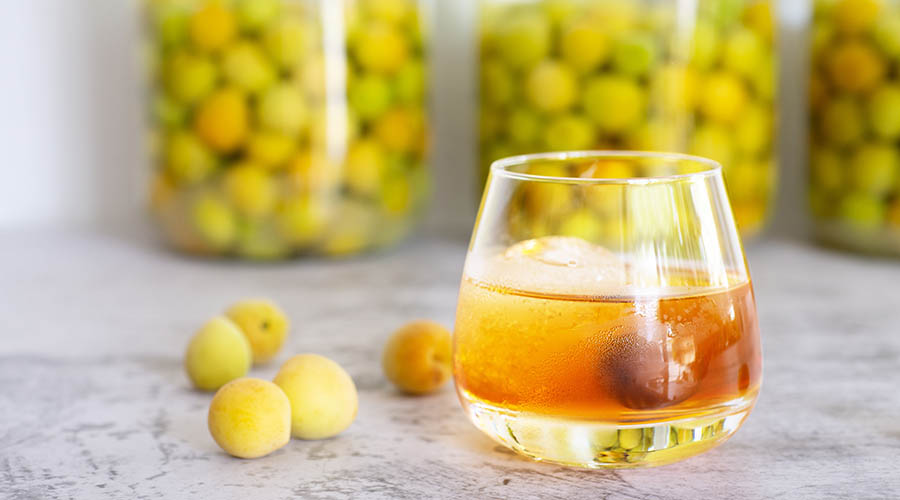 Un verre d'Umeshu servi avec une prune